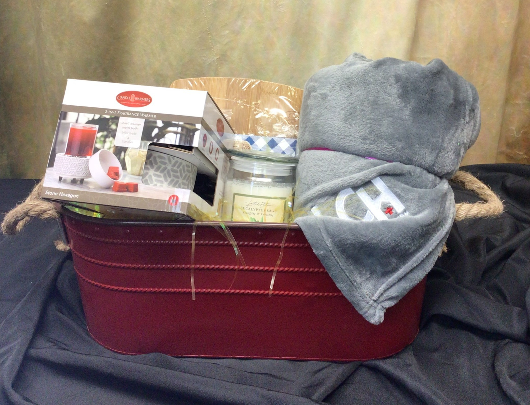 Fragrance warmer, LCHD charcuterie board, LCH blanket, essential oils candle, & red bucket.