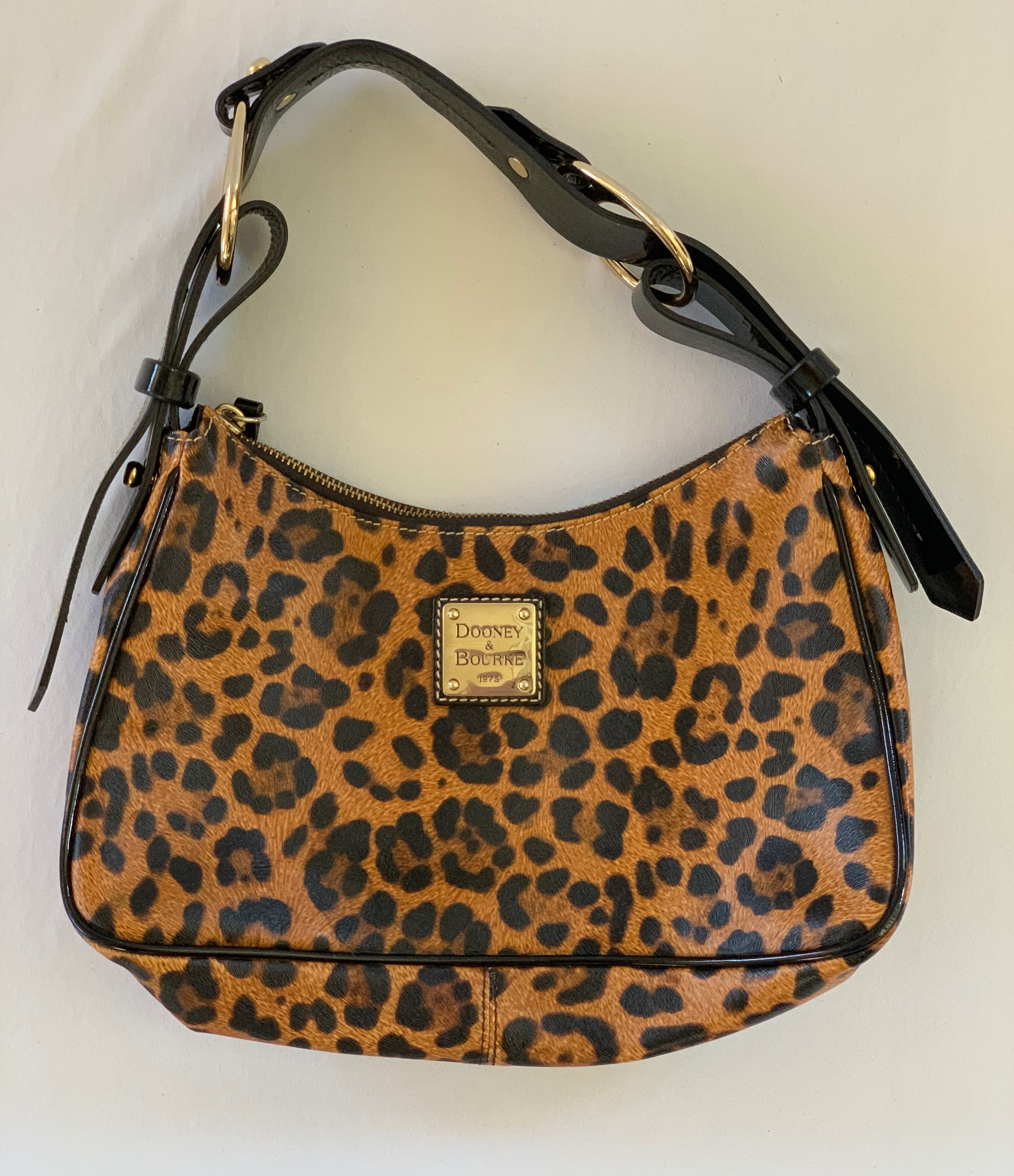 Leopard print leather medium shoulder bag with red patent leather interior. Exterior in great condition, interior has minor staining.