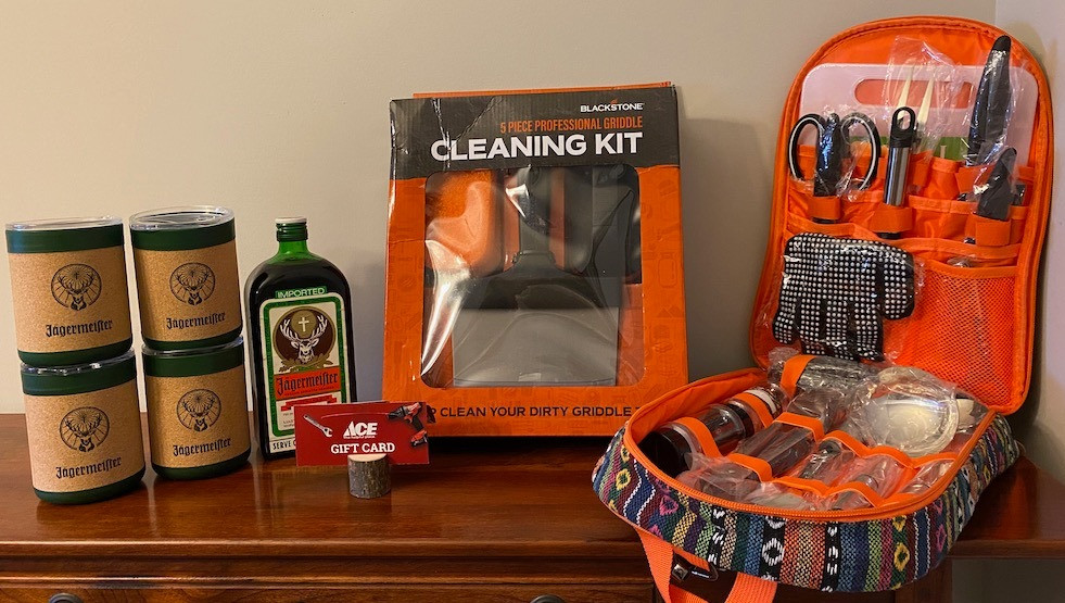 17-piece camping utensil set in a fun backpack, plus a $50 Ace Hardware gift card, a bottle of Jagermeister with tumblers, and a 5-piece griddle cleaning set.