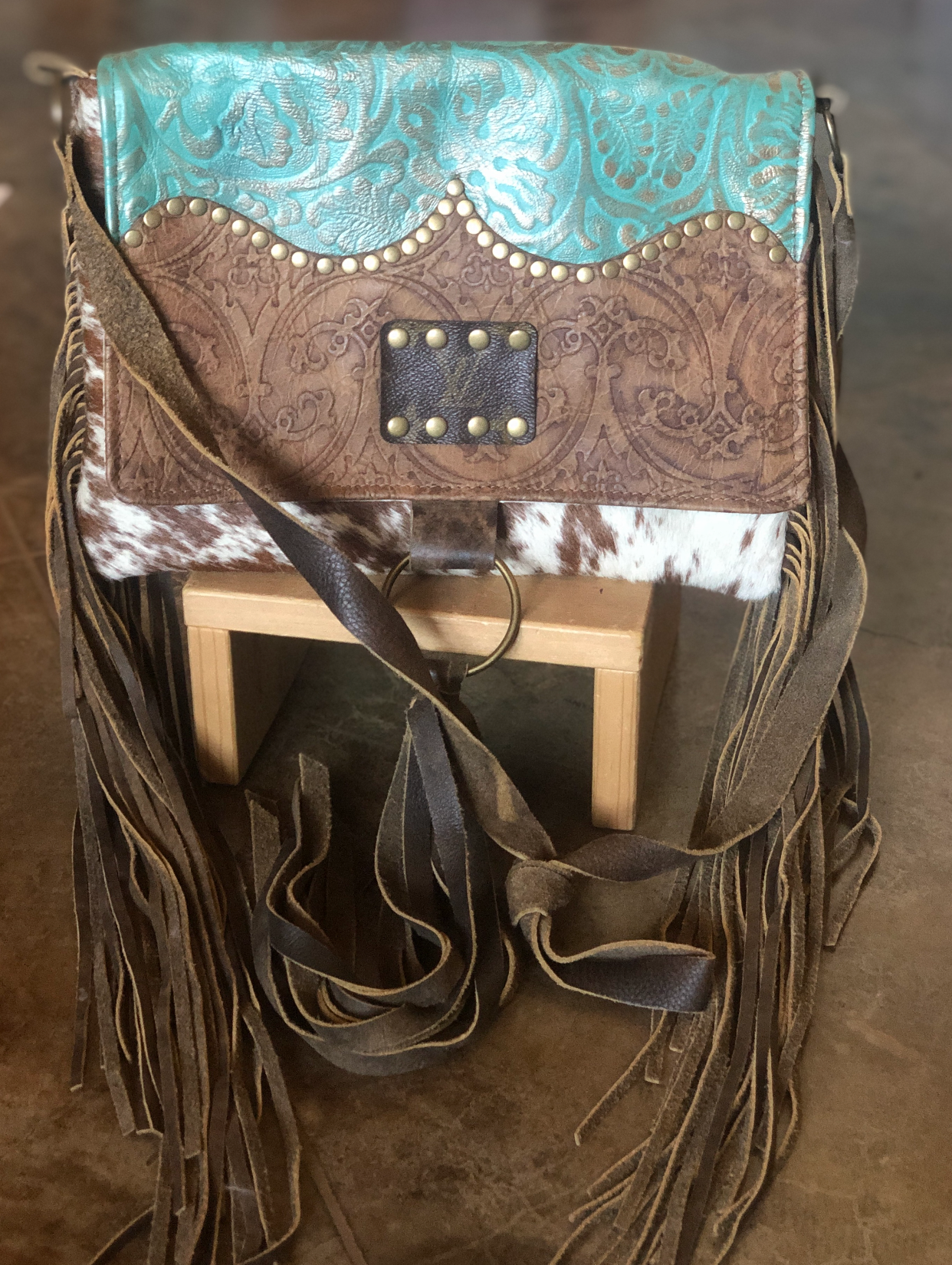 Handmade turquoise leather crossbody with “LV” dupe accent, cowhide and fringe.  Minor interior stain