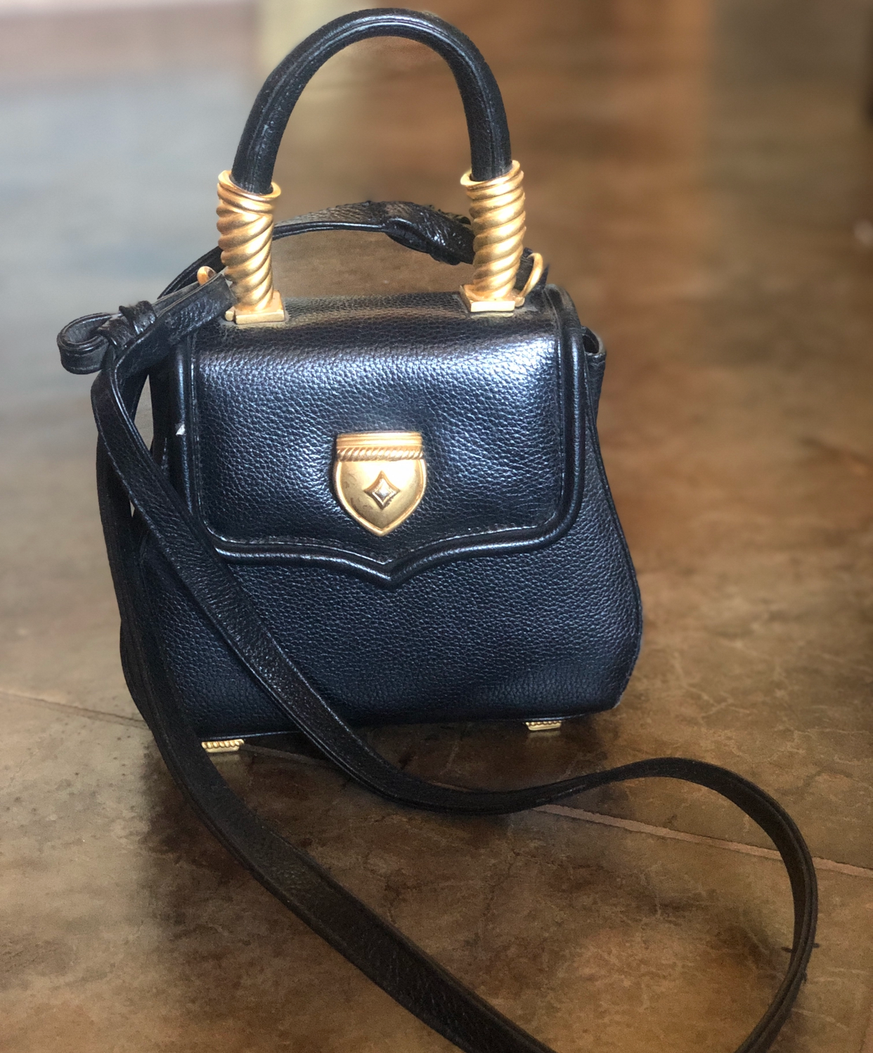 Small black crossbody with gold hardware.  Some wear and tear.