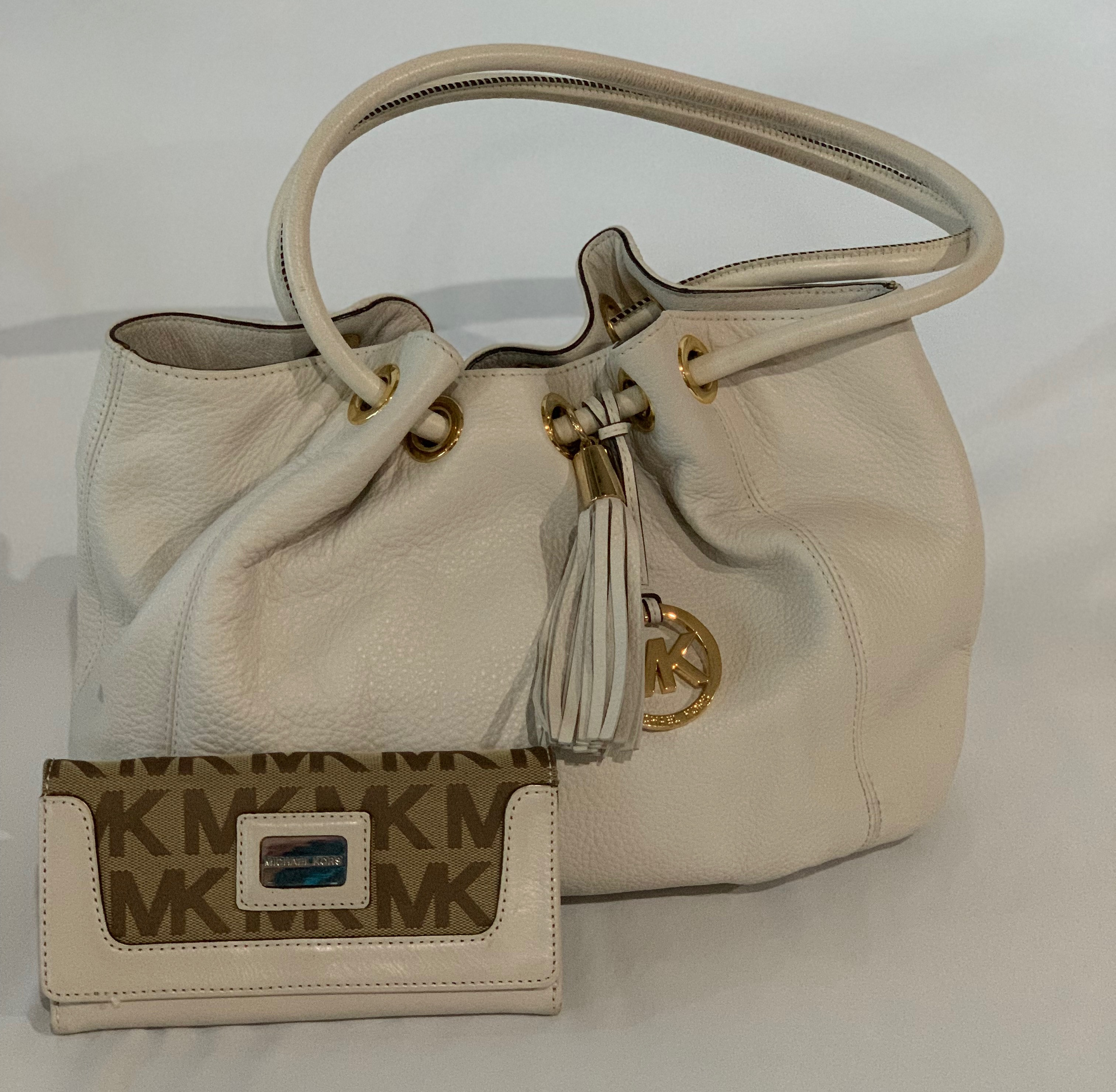 Winter white scrunch handbag with matching wallet. Small scuff marks on bottom of bag, otherwise great condition. Wallet has makeup staining on inside flap, otherwise in good condition.