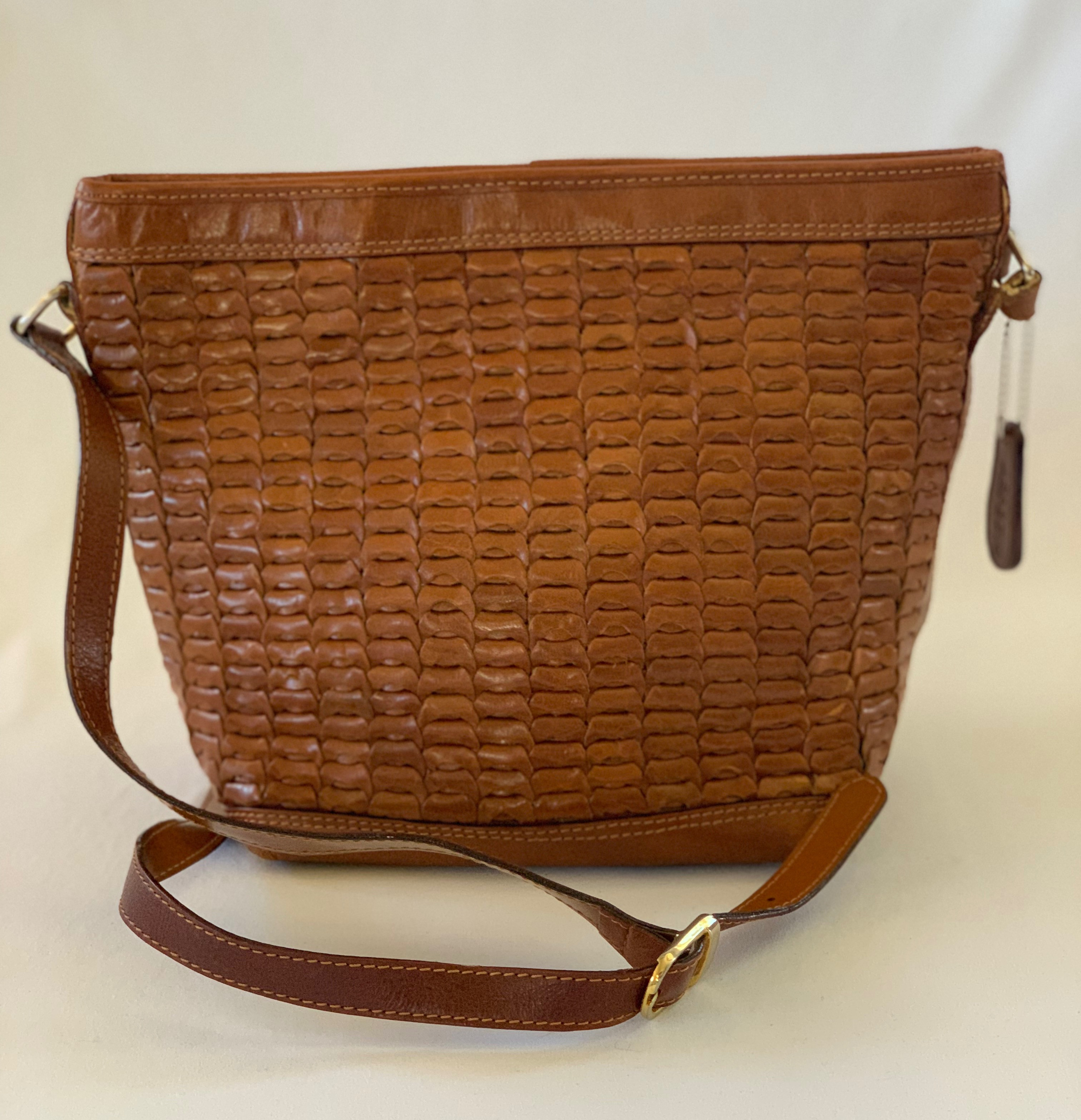 Saddle brown shoulder bag with faux weaving on front. Interior has some ink staining.