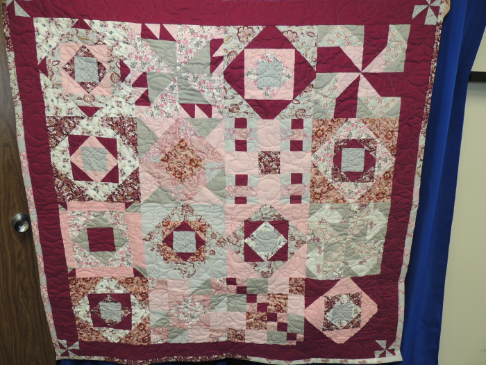 A beautiful, handmade quilt. The quilt features beautiful shades of pink with beautiful floral prints added into the mix.