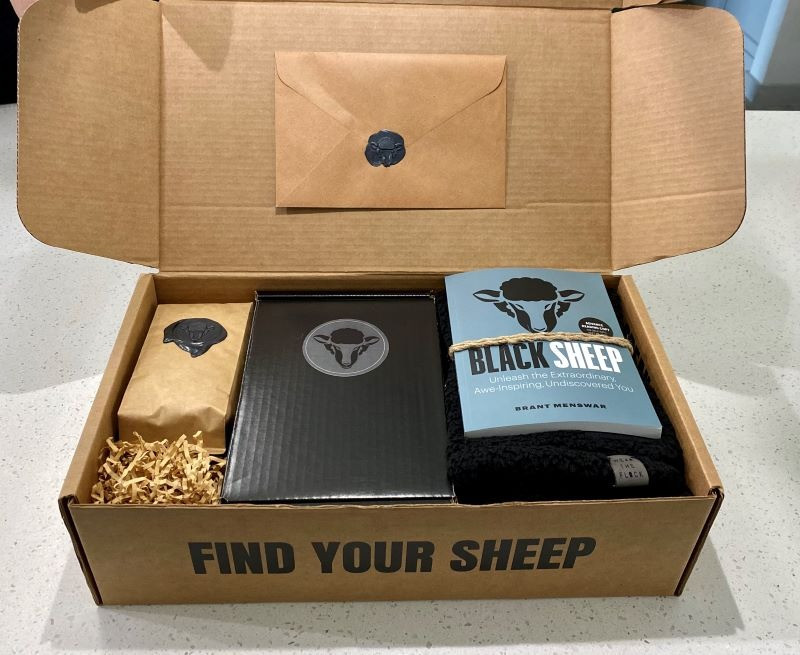 Brant Menswar "Black Sheep" Limited Edition Gift Box. Includes autographed "Black Sheep" book, sherpa wool scarf, coffee mug, private labeled coffee, sticker and t-shirt. Menswar, the 2020 AALAS National Meeting Keynote Speaker, is a core values activist, former rock star and one of the country's "Top 10 Motivational Speakers". Brant encourages audiences to discover their "Black Sheep Values" and move forward with deliberate intention.