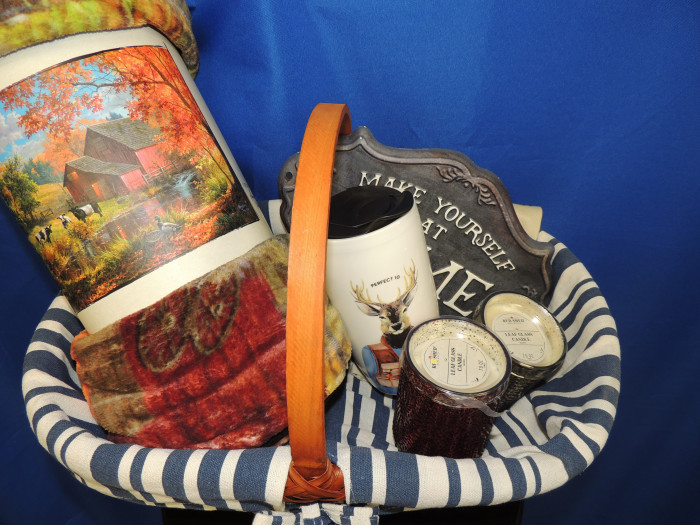 A beautiful soft farm themed blanket with a deer themed coffee mug, 2 Lead Glass candles and a "Make Yourself at Home" sign, nestled in a cute round bottom basket.