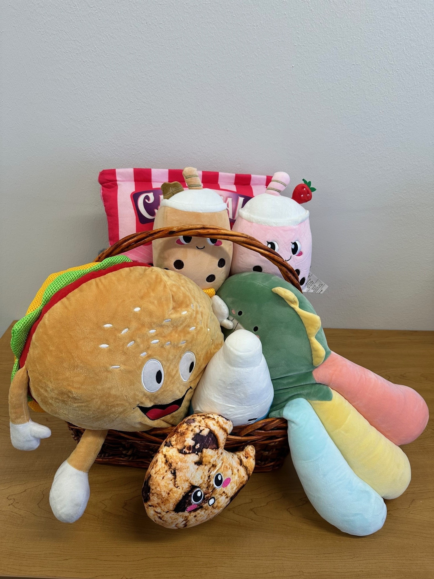 This basket is full of plushies! Enjoy a Carnival Cookie Plushie, Dinosaur Plushie, BFF Milk & Cookie Plushie Set, BFF Boba Plushie, Hamburger Plushie, and Notebook.