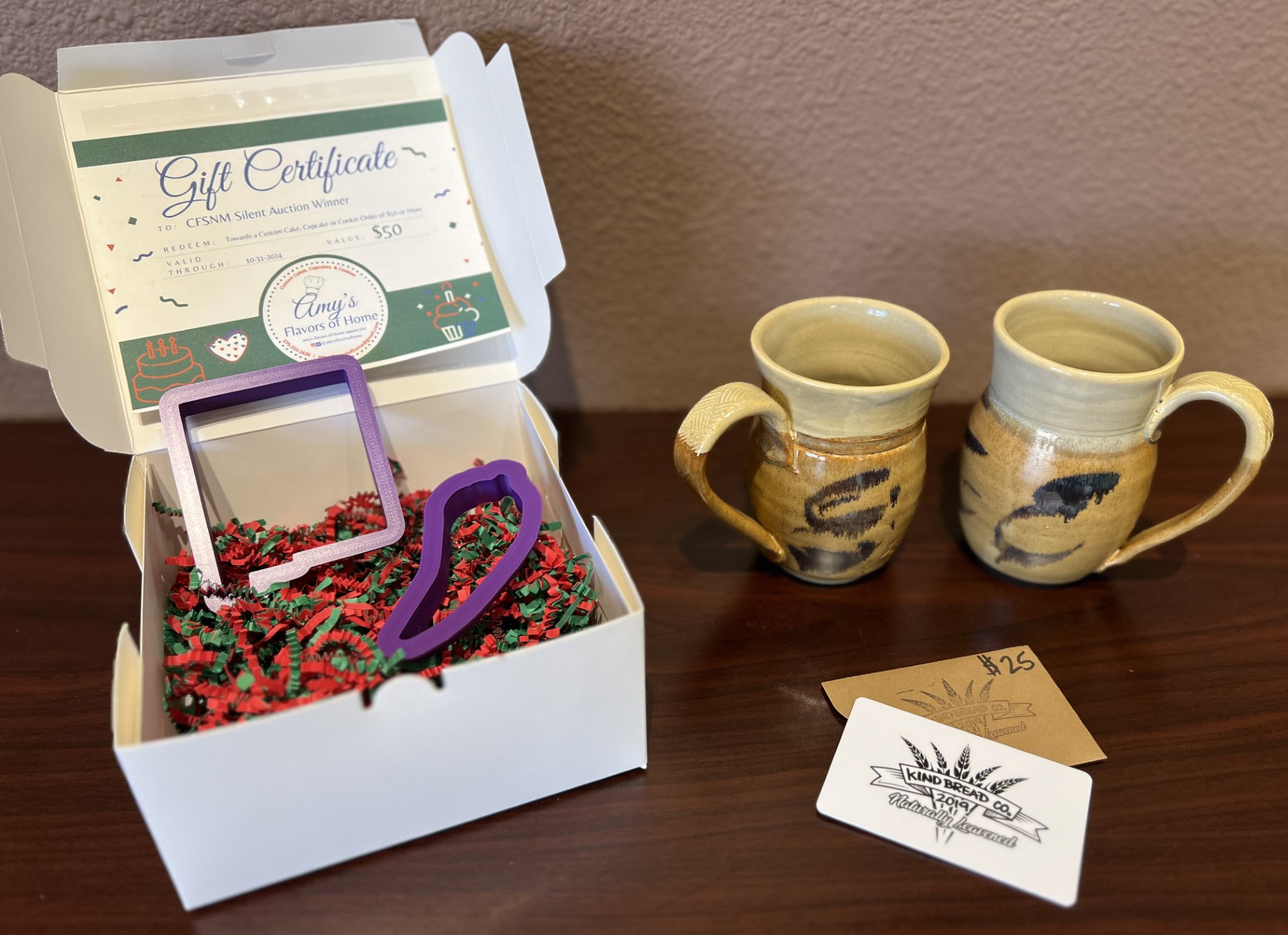 $25 Gift Certificate to Kind Bread Co. with (2) handmade mugs from Cally Williams, $50 Gift Certificate to Amy's Flavors of Home and NM Cookie Cutters