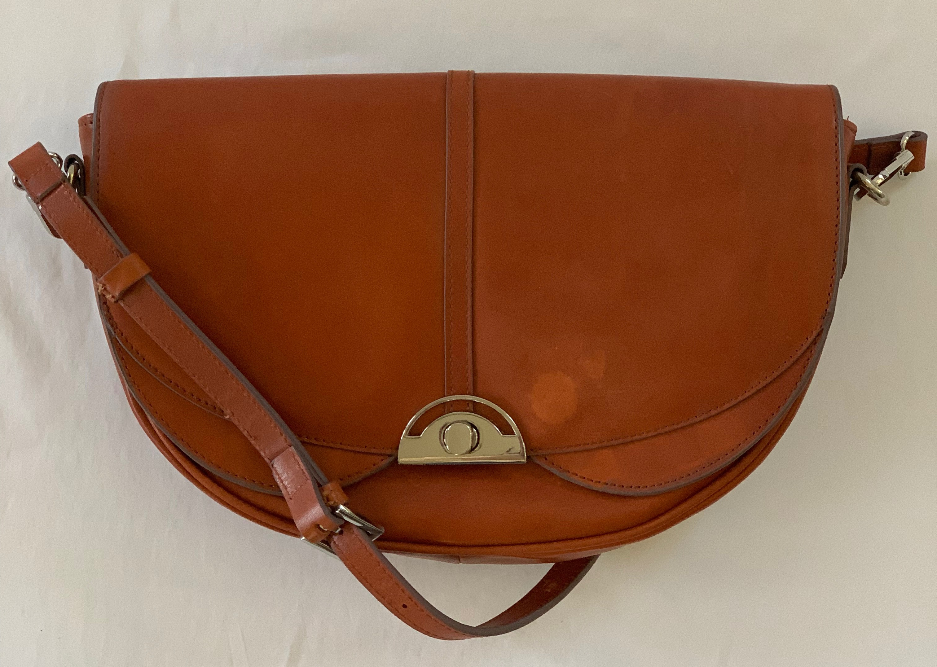 Saddle brown leather crossbody. In great condition except for small water spots on front and a little wear on flap.