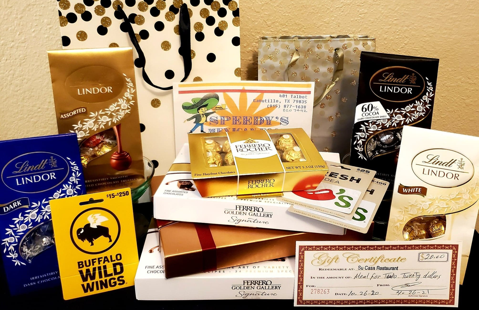 1 - $20 giftcard for Buffalo Wild Wings, 2 - giftcards for Chili's totaling $45, 1 - $20 gift certificate for Su Casa Restaurant, 1 gift certificate to Speedy's Mexican Food, 4 bags (20 oz) of Lindor chocolate, 1 box (7.3oz) of lindor truffles, 3 boxes of Ferrero chocolate.