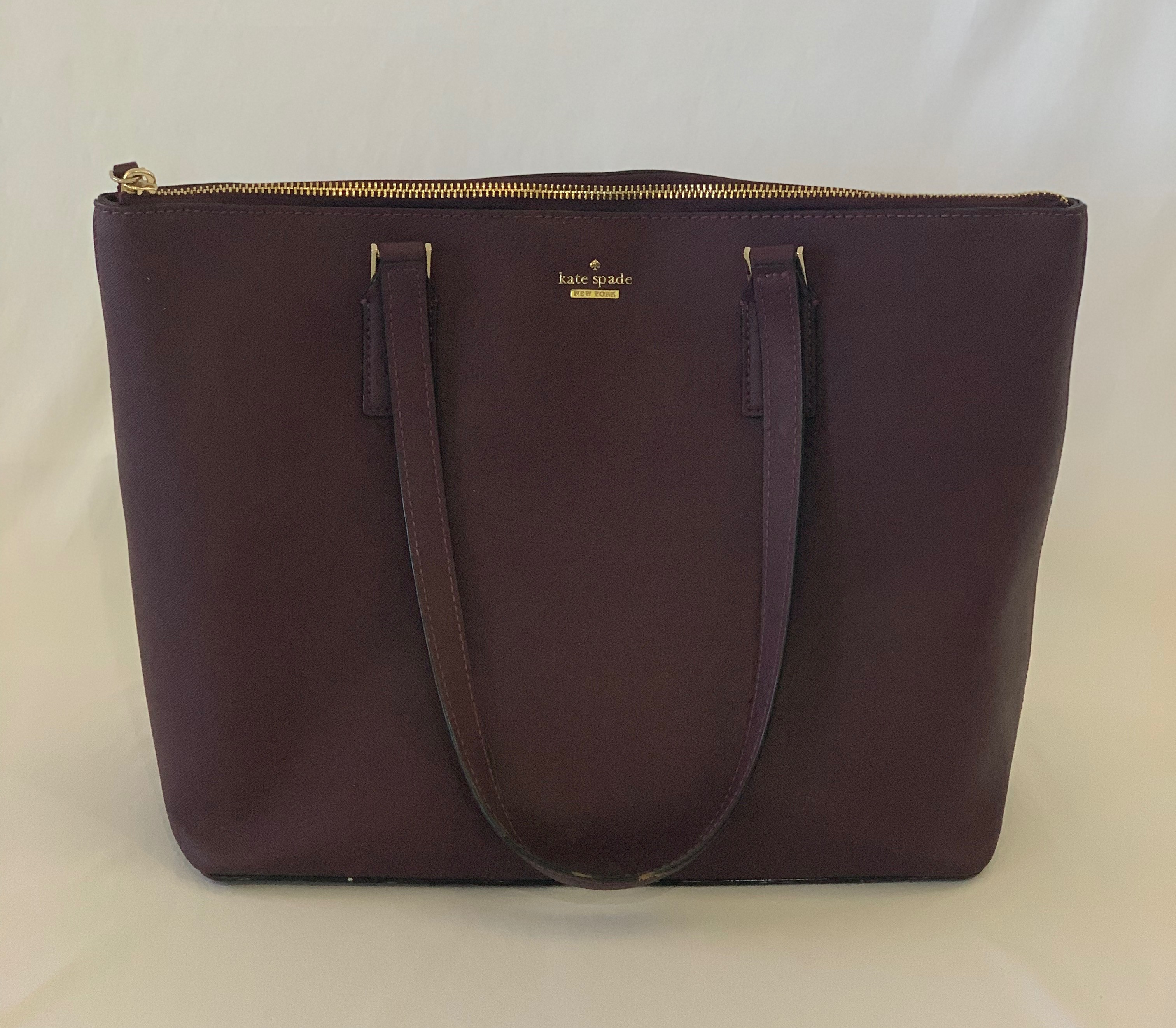 Plum berry medium tote. Exterior has one scuff on bottom. Interior has some staining throughout.